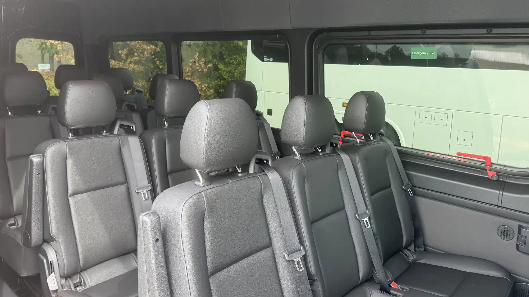 California Wine Tours sprinter van interior with black leather passenger seats and seatbelts arranged for group travel