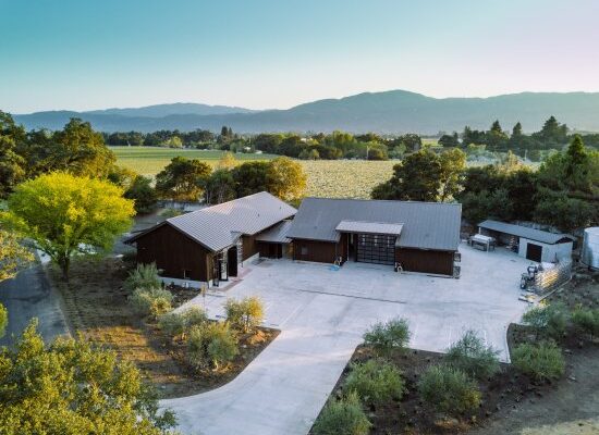 Overhead view of a house with a driveway, set against a backdrop of mountains, representing the Dakota Shy area.