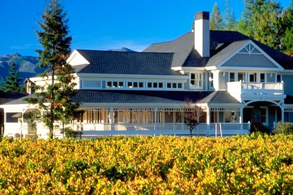 A large house with a vineyard in front, showcasing the scenic beauty of Duckhorn estate.