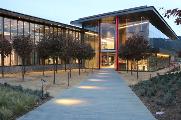 Night view of the new building's entrance, featuring bright lights and a sleek design that invites visitors inside.