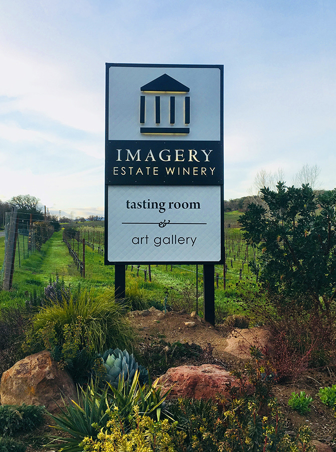 imagery Imagery Estate Winery sign located in a vibrant field, highlighting its tasting room and art gallery.