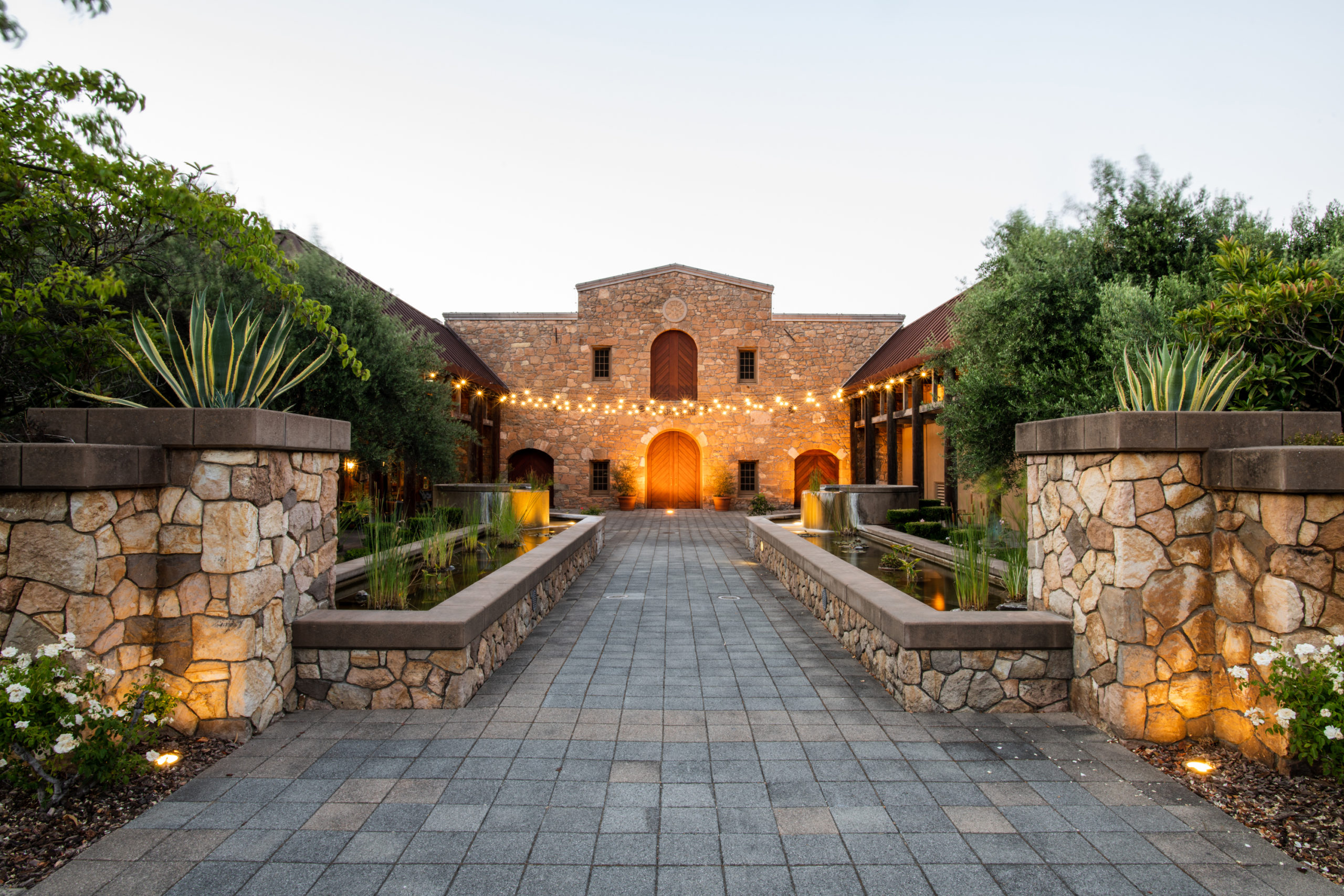 Entrance of a large stone building in Markham, illuminated by lights, showcasing its architectural details at night.
