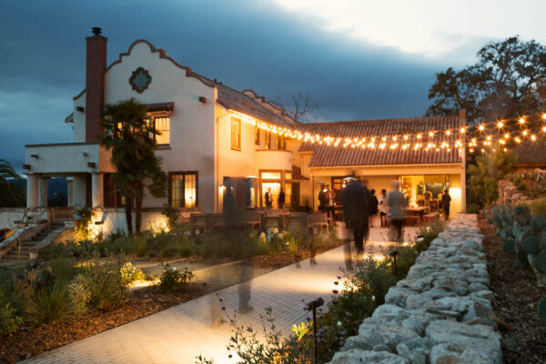 A cozy house adorned with string lights illuminating the walkway, creating a warm and inviting atmosphere.