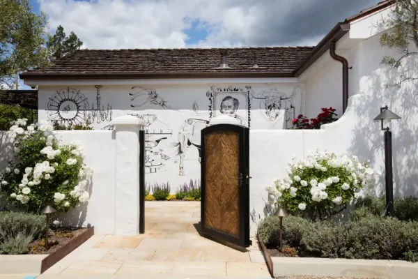 A modern white house with a bold black door and white walls, creating a fresh and inviting appearance.