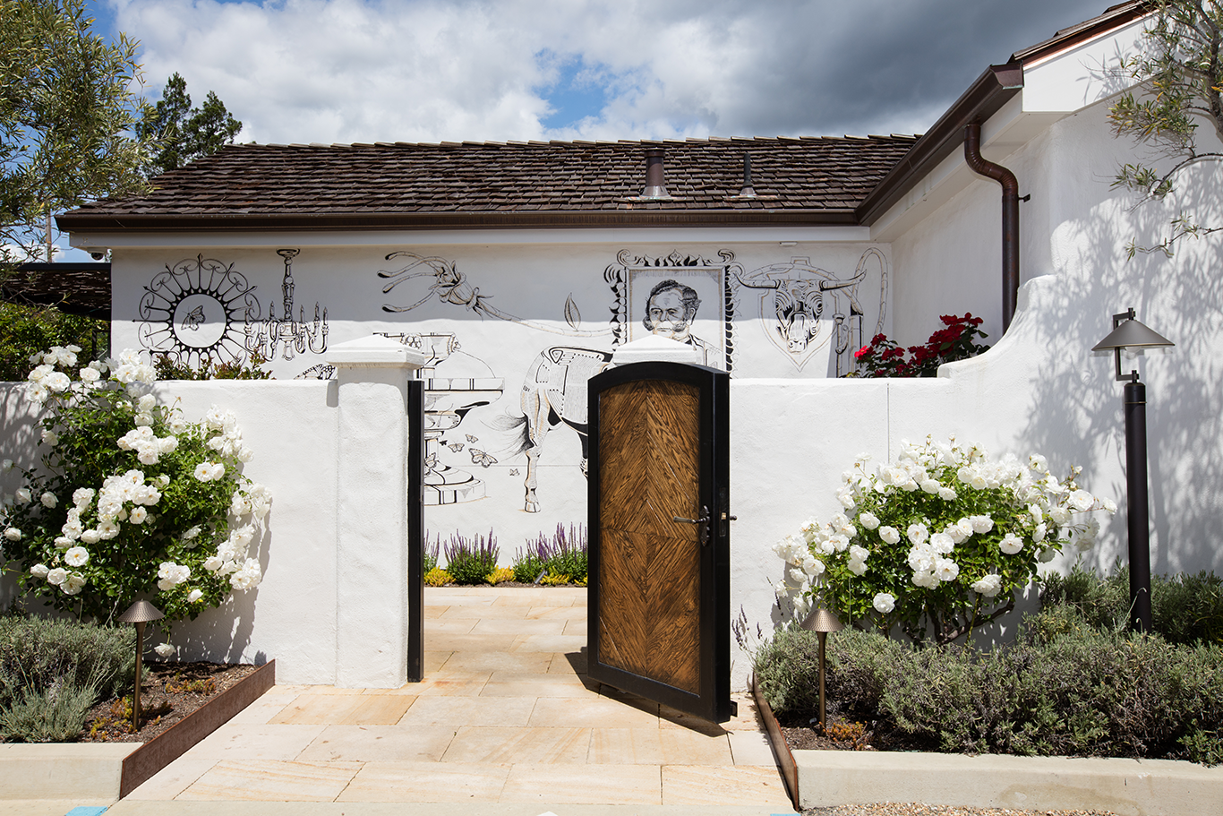 A modern white house with a bold black door and white walls, creating a fresh and inviting appearance.