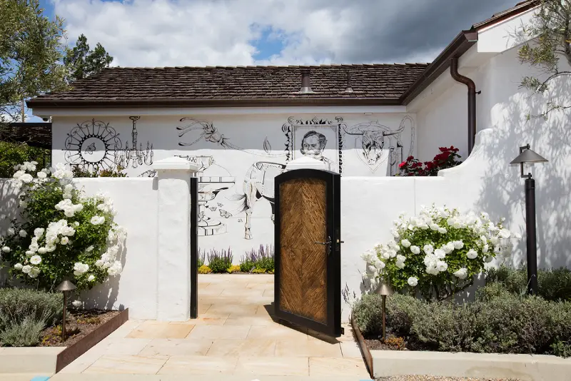 A modern white house with a bold black door and white walls, creating a fresh and inviting appearance.