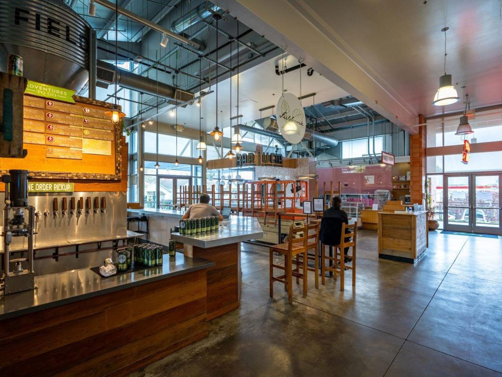 inside a market with tables and chairs and brewery