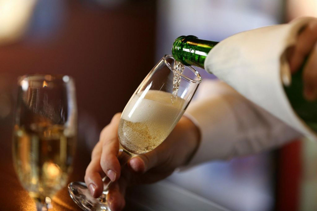 person pouring champagne into a glass