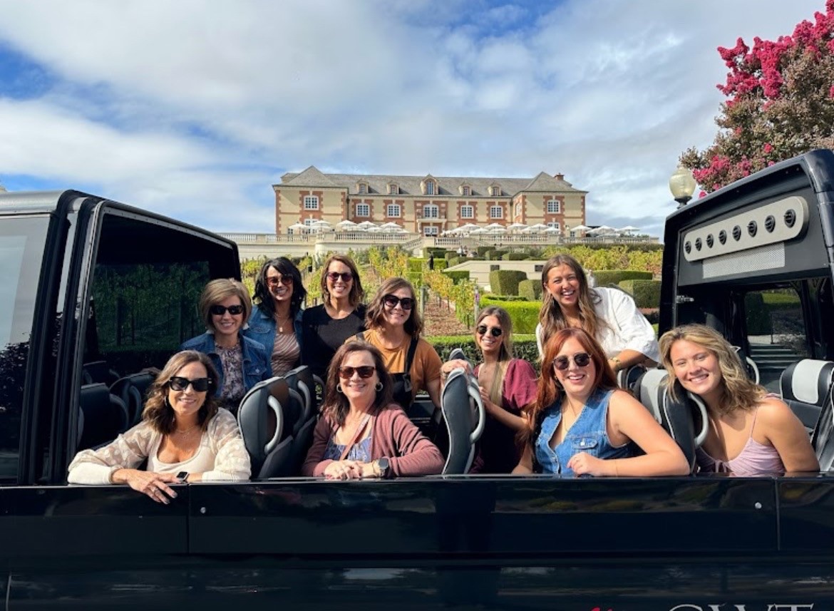 convertible open air shuttle with happy guests in front of winery