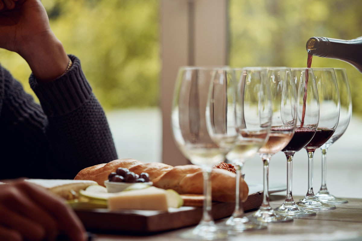 wine tasting at a counter with a cheese board as well